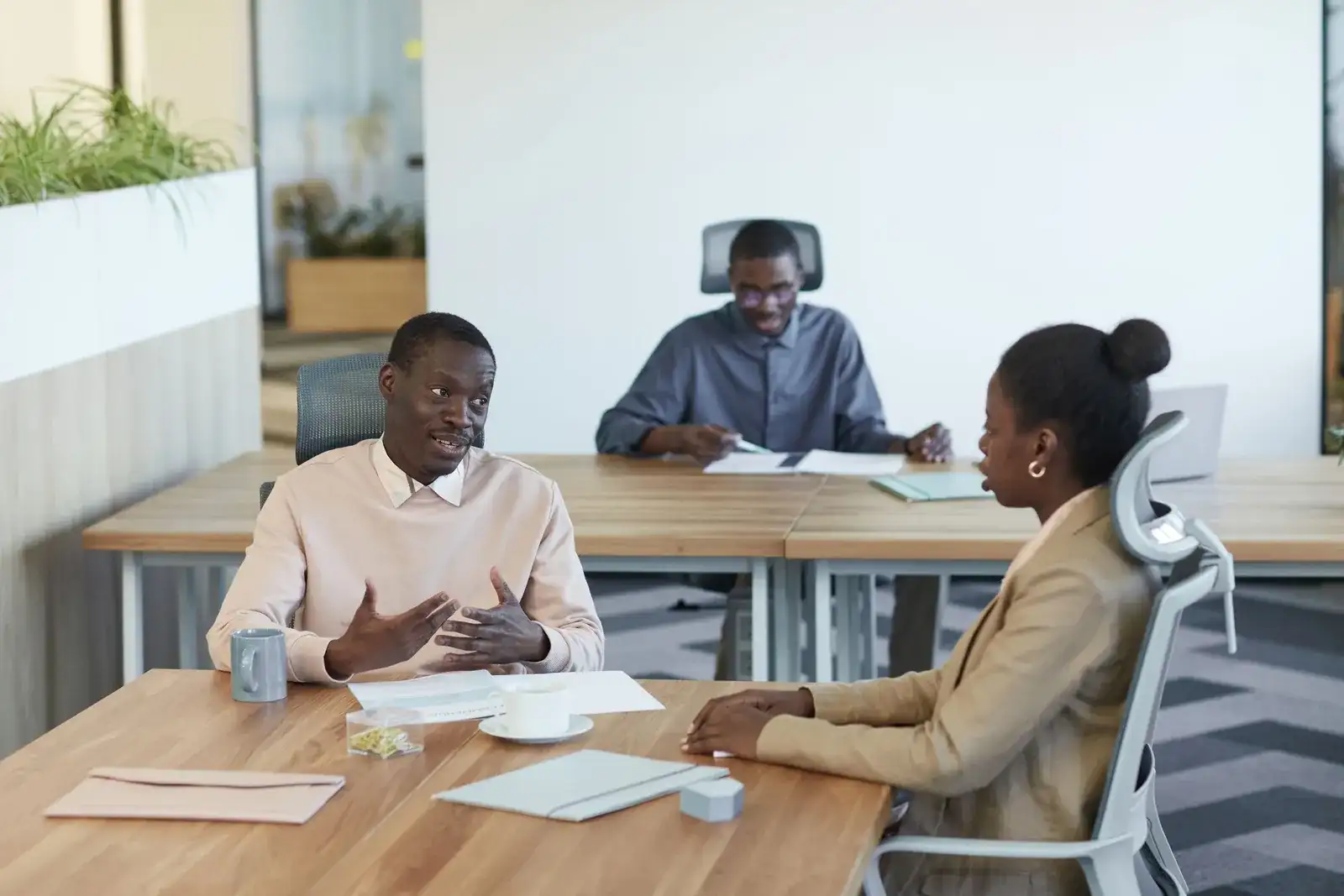 A man explains a point to a colleague across a meeting table